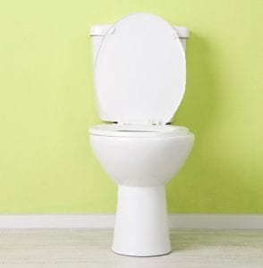 A white toilet with a green wall
